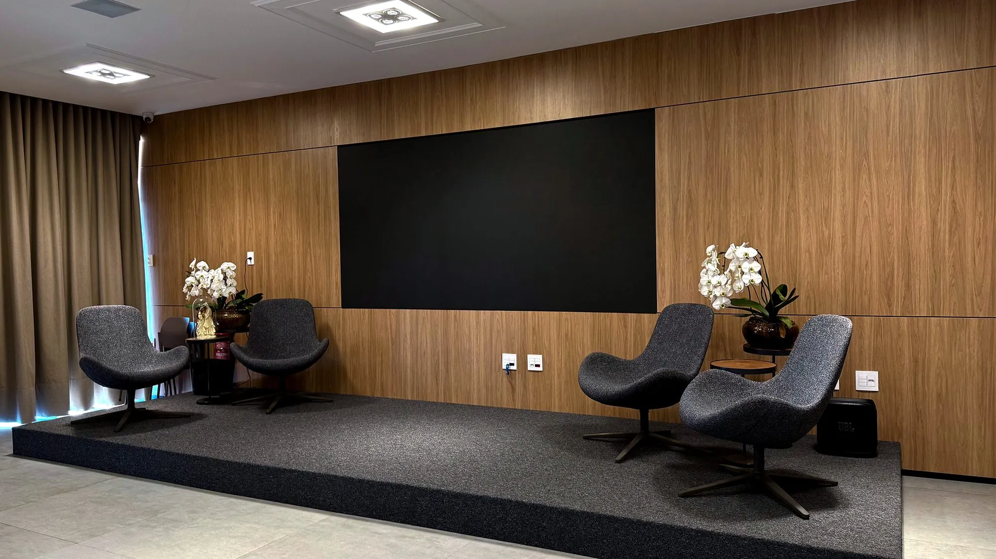 Auditório com telão de LED e painel de madeira