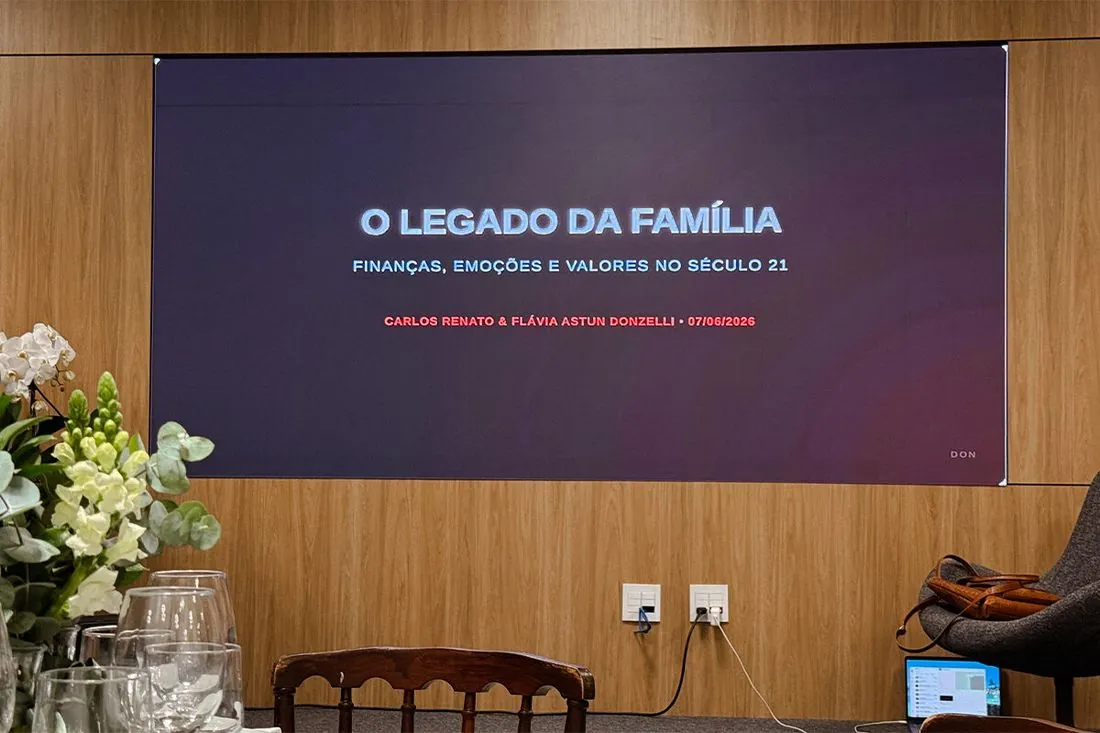 Salão montado para jantar com o telão da palestra ao fundo