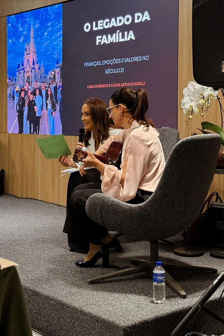 Palco montado com poltronas e telão durante a palestra