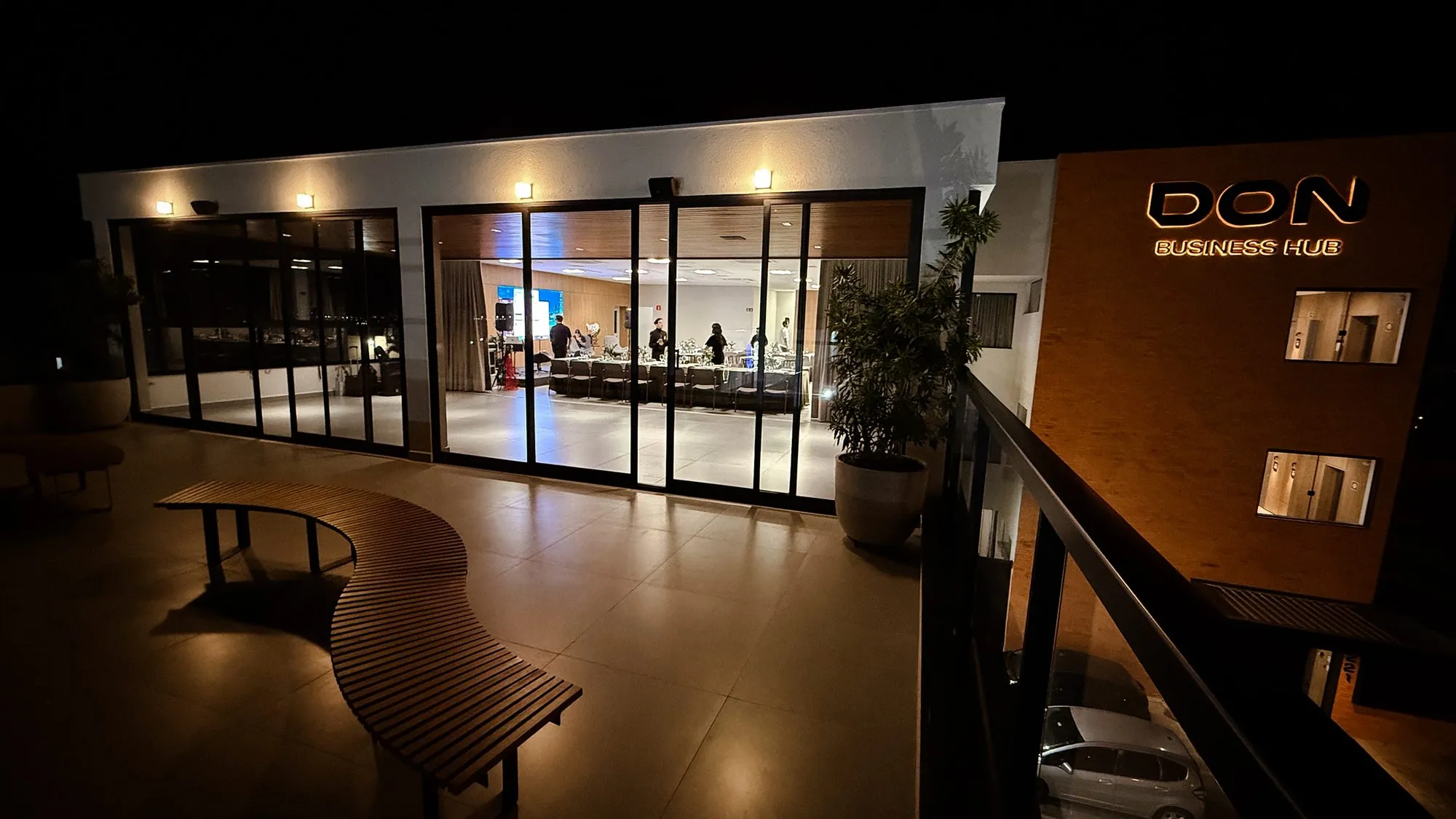 Fachada iluminada do DON Business Hub à noite